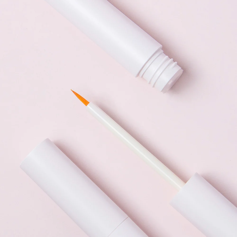 White empty eyeliner tube with fine pointed brush applicator, cosmetic packaging for liquid makeup
